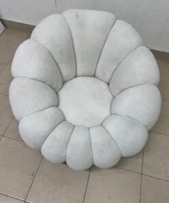 The Fana "Flower" chair from Home Centre is a lounge chair featuring a floral-inspired design and upholstered in soft, comfortable bouclé fabric; it is distinguished by its rounded shape—resembling petals or a pumpkin. - Image 5