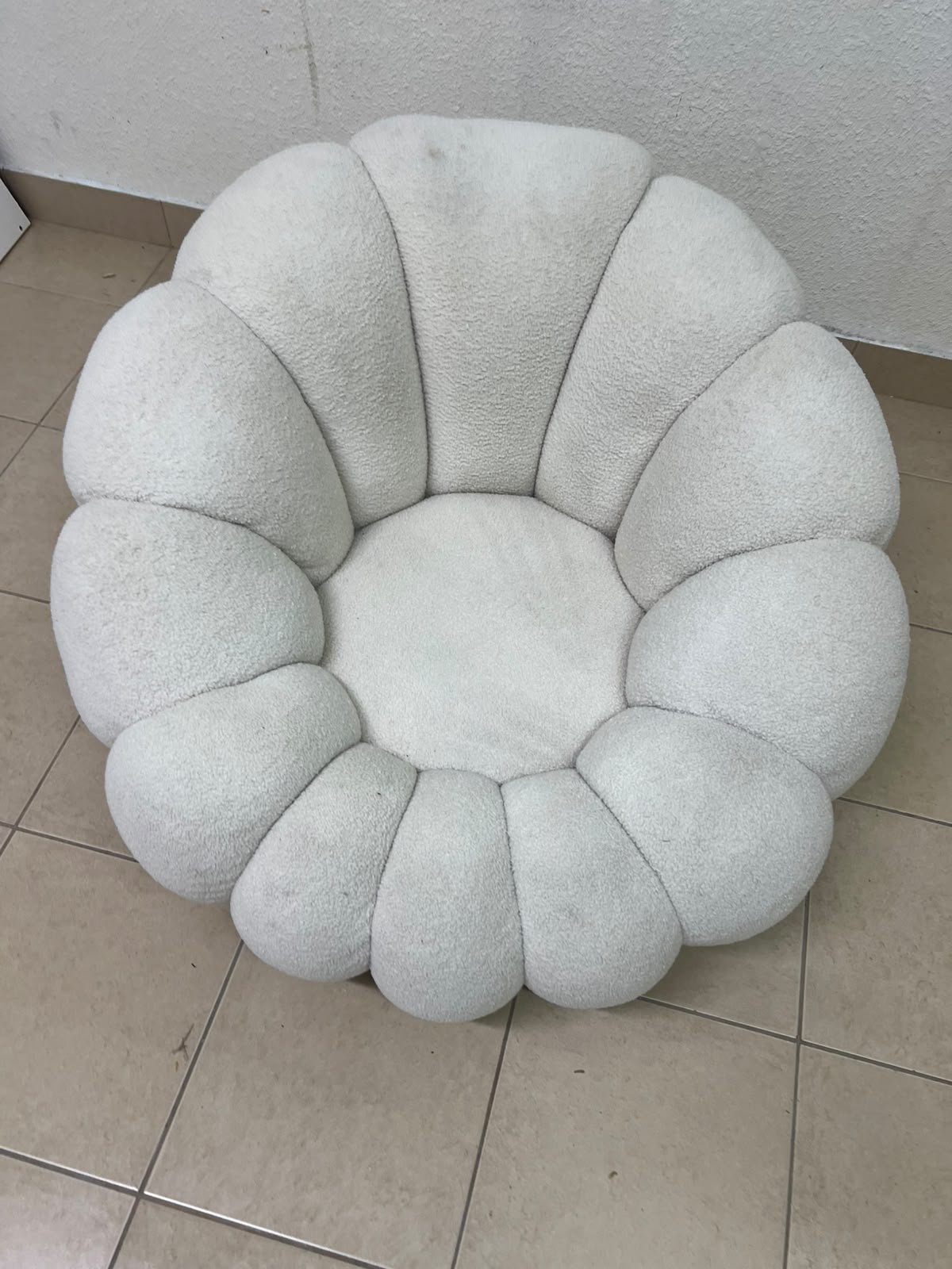 The Fana "Flower" chair from Home Centre is a lounge chair featuring a floral-inspired design and upholstered in soft, comfortable bouclé fabric; it is distinguished by its rounded shape—resembling petals or a pumpkin. - Image 5