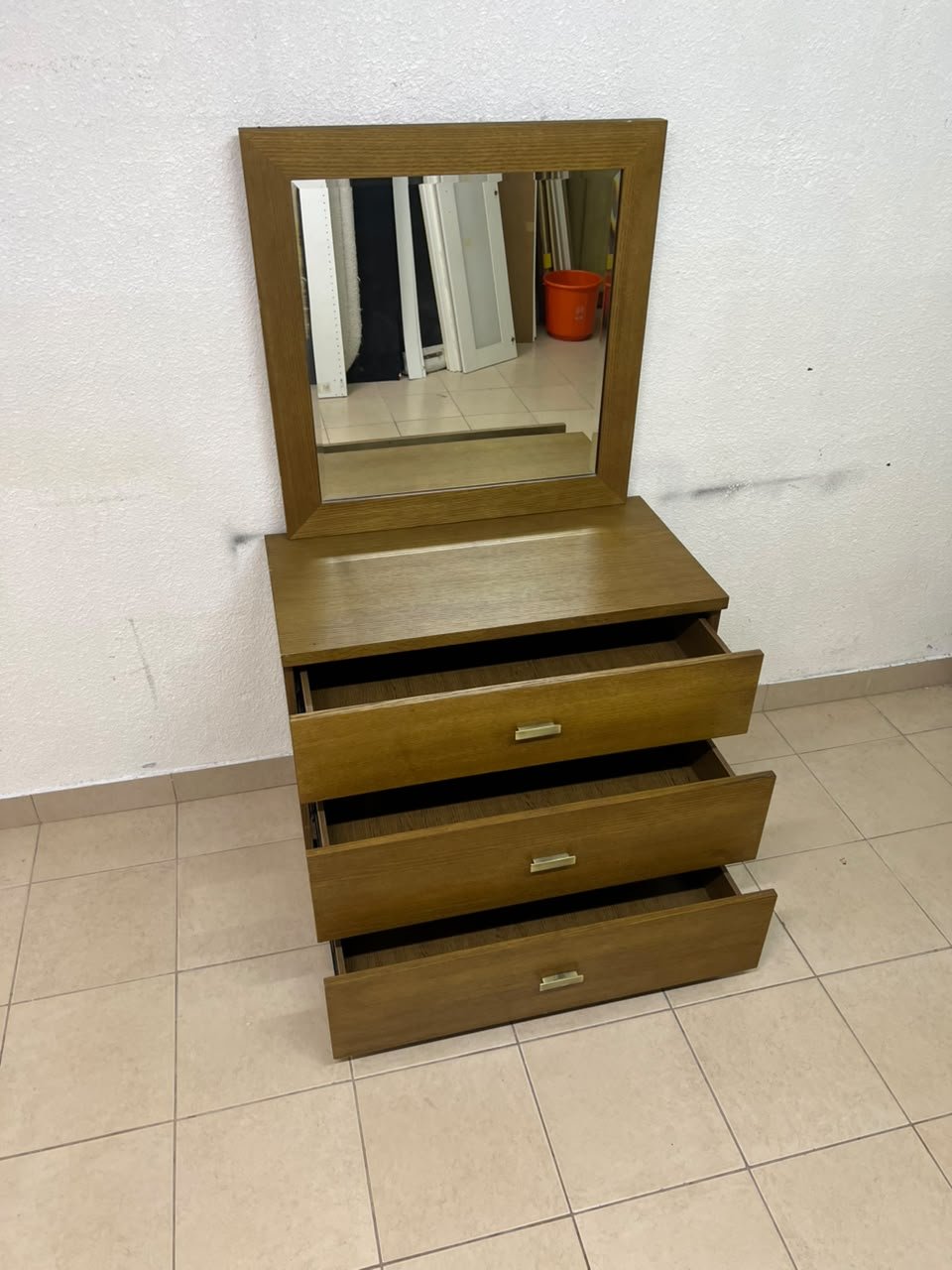 A wooden drawer unit (dressing table) featuring three drawers and metal handles, accompanied by a square mirror with a matching wooden frame—resembling designs found at brands like Pan Emirates or Home Centre. - Image 2