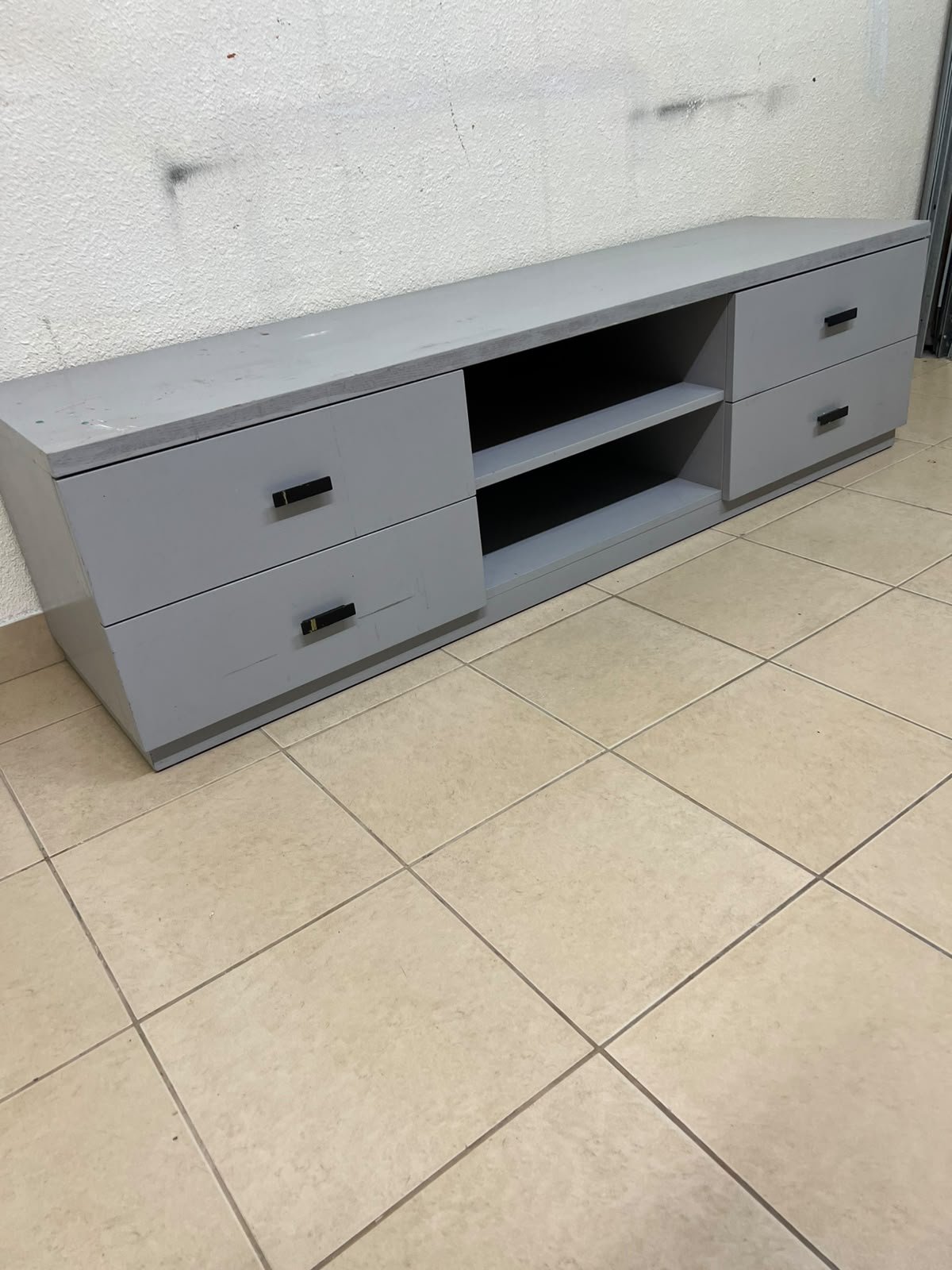 A grey TV stand featuring a modern design and side drawers equipped with stylish black handles. - Image 2