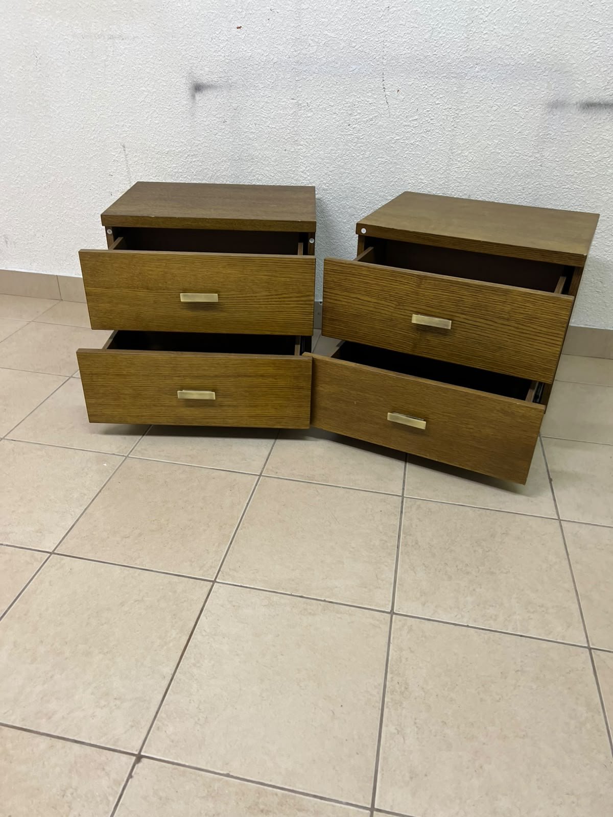 Two wooden side tables in a warm brown hue, featuring an elegant design with two drawers and distinctive metal handles. - Image 3
