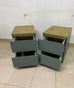 A bedside table featuring a minimalist design, grey-green drawers, and a wooden or yellowish top surface; the style resembles modern storage furniture. - Image 3