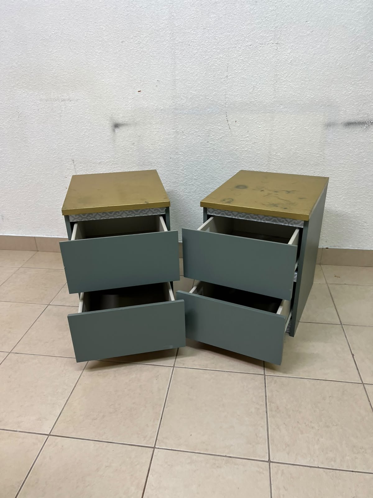 A bedside table featuring a minimalist design, grey-green drawers, and a wooden or yellowish top surface; the style resembles modern storage furniture. - Image 9