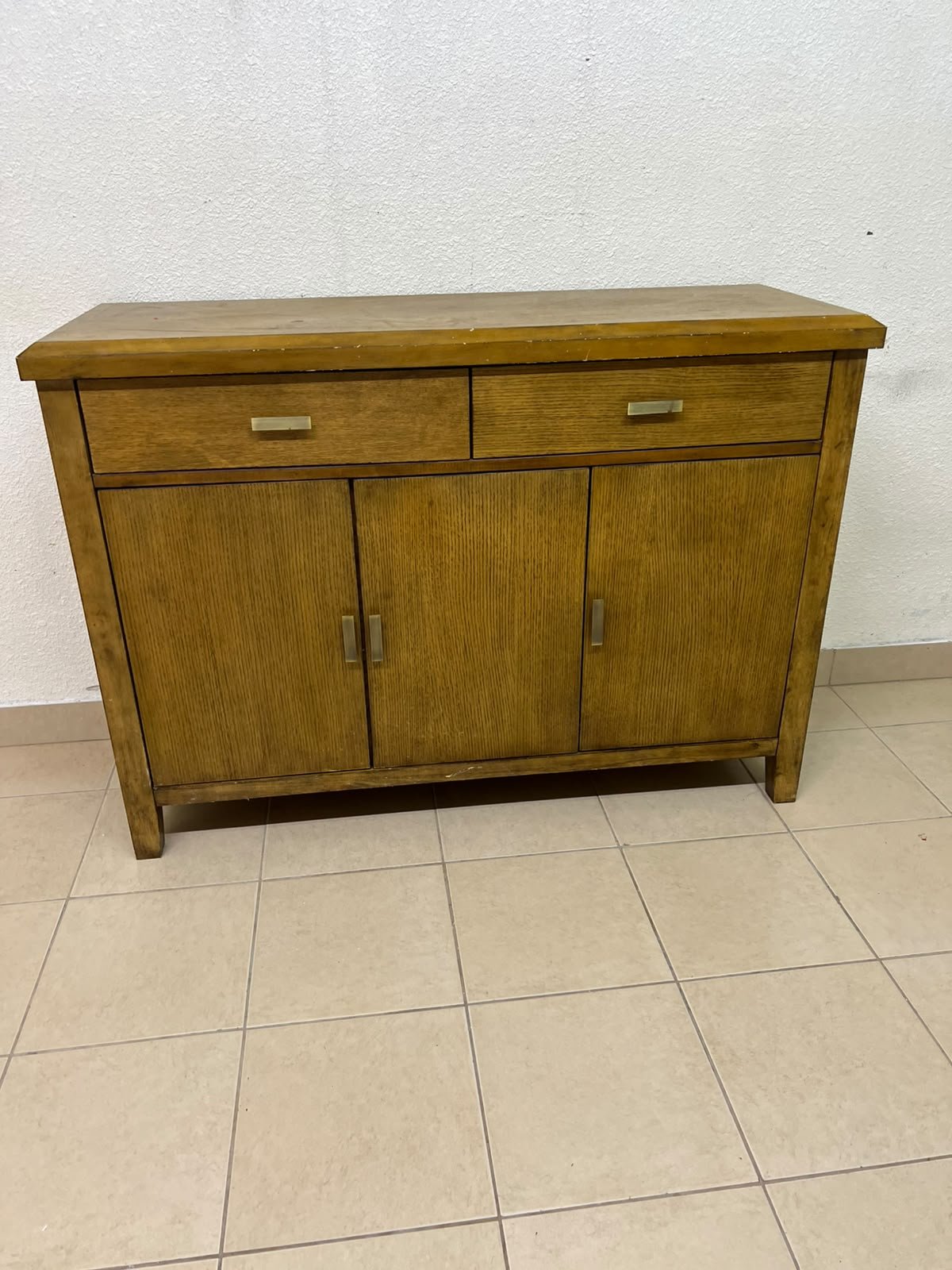 A practical wooden sideboard featuring two upper drawers and three doors fitted with stylish metal handles.