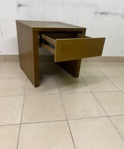 This wooden table—featuring a distinctive finish and a single drawer—is a piece of Czech furniture that complements contemporary bedroom décor.