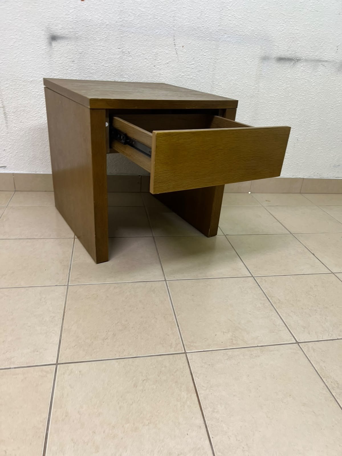 This wooden table—featuring a distinctive finish and a single drawer—is a piece of Czech furniture that complements contemporary bedroom décor.