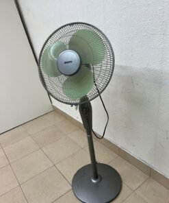 A Sanyo-branded grey pedestal fan featuring light green blades and a circular base.