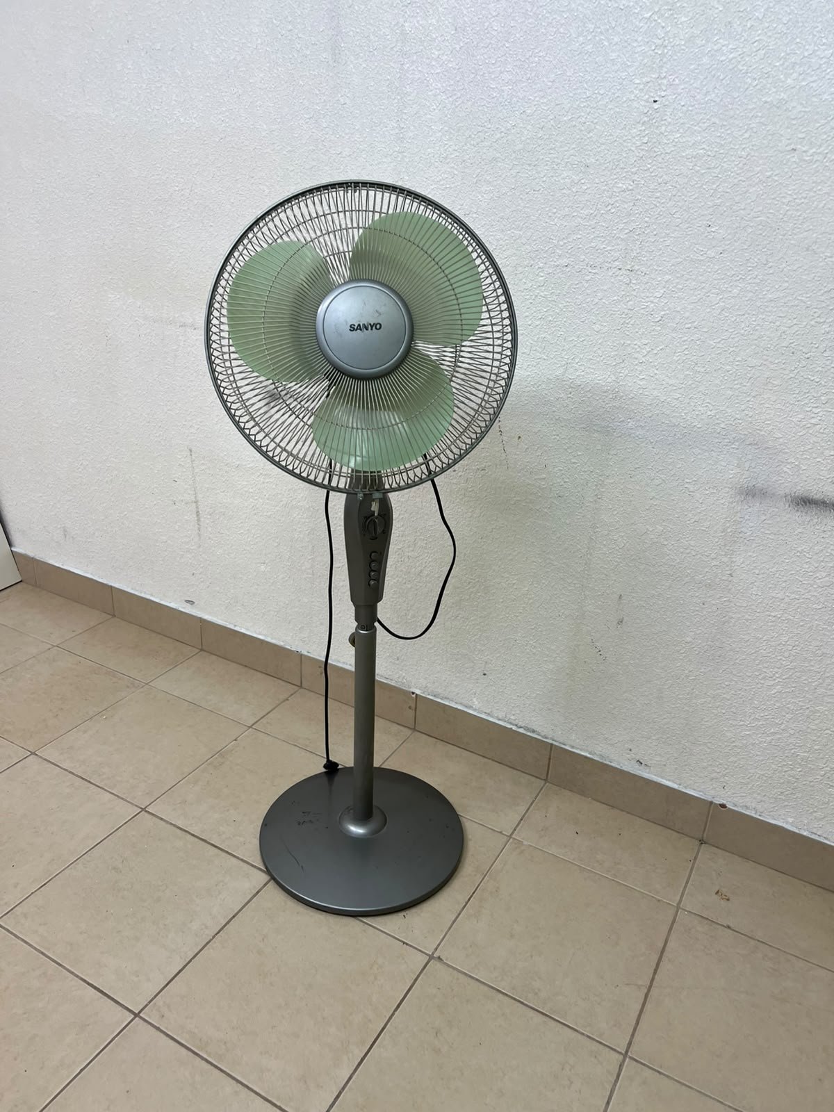A Sanyo-branded grey pedestal fan featuring light green blades and a circular base. - Image 2