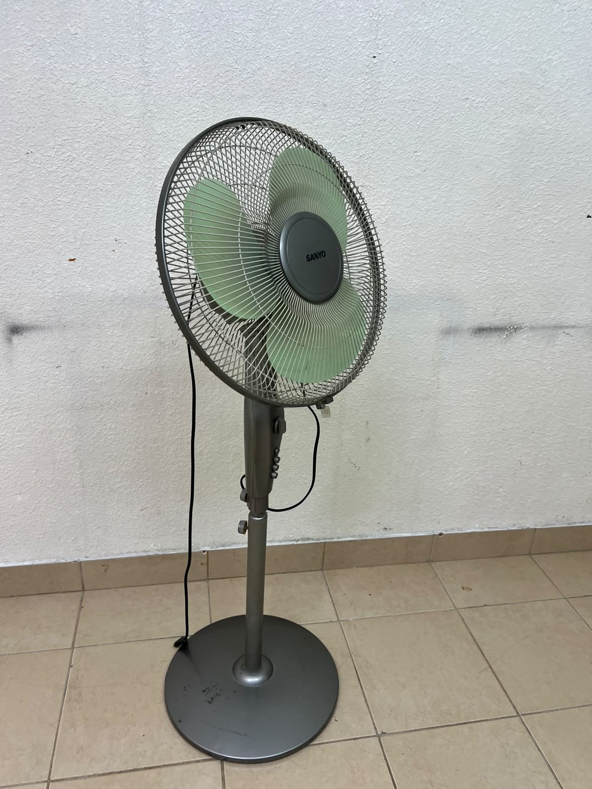 A Sanyo-branded grey pedestal fan featuring light green blades and a circular base. - Image 6