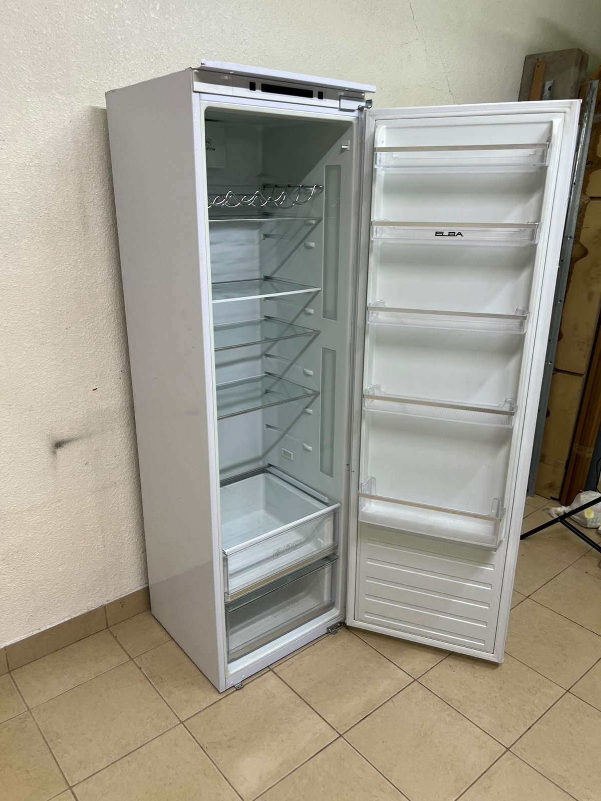 An Elba built-in single-door refrigerator featuring a white design, adjustable glass shelves, and a metal bottle rack. - Image 6