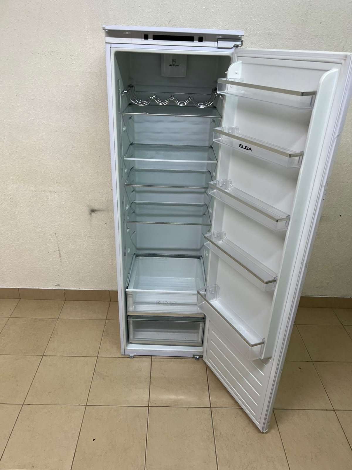 An Elba built-in single-door refrigerator featuring a white design, adjustable glass shelves, and a metal bottle rack. - Image 7