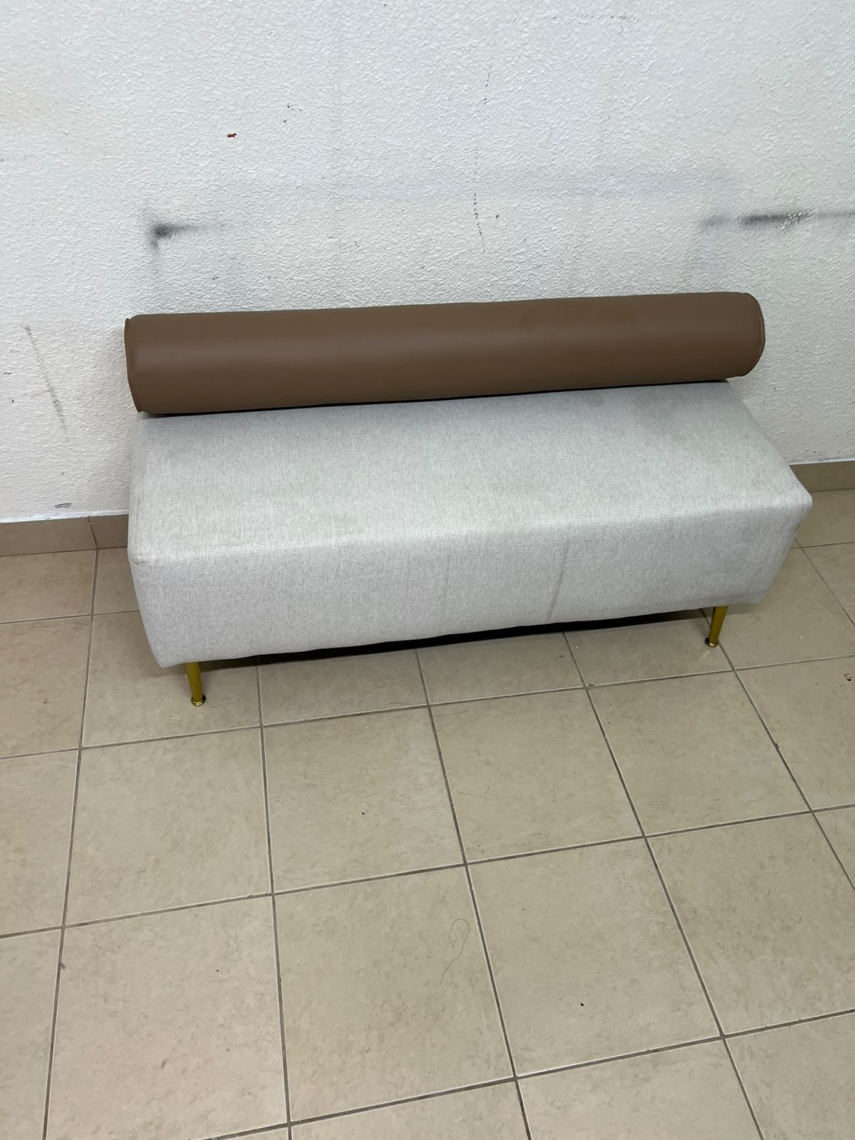 The light-gray upholstered seat, featuring a brown cylindrical backrest and gold legs, is a stylish, modern piece of furniture that adds a distinctive touch to the décor. - Image 3