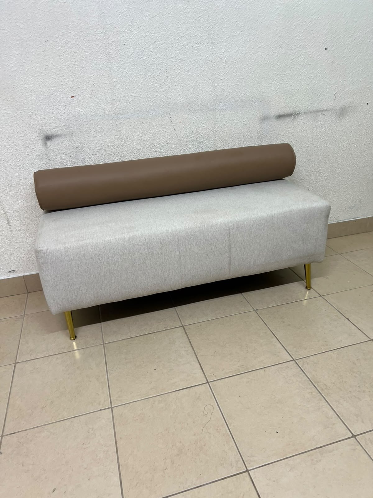 The light-gray upholstered seat, featuring a brown cylindrical backrest and gold legs, is a stylish, modern piece of furniture that adds a distinctive touch to the décor. - Image 4