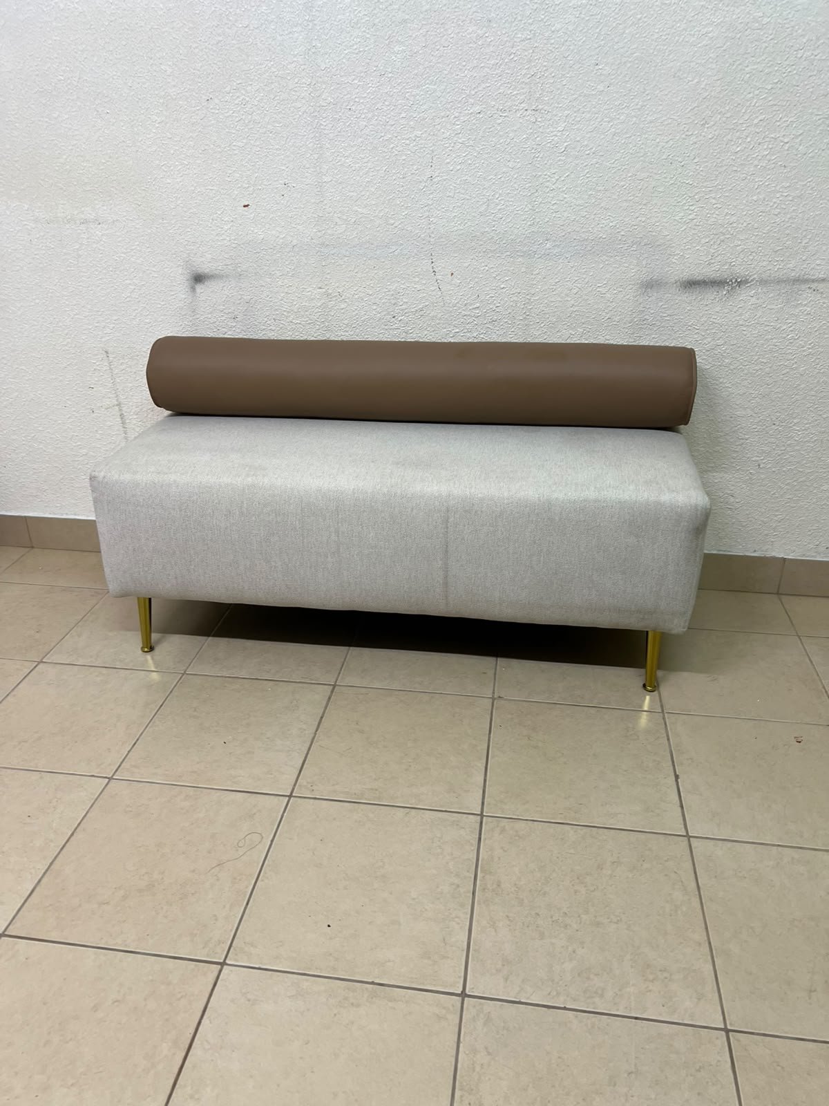The light-gray upholstered seat, featuring a brown cylindrical backrest and gold legs, is a stylish, modern piece of furniture that adds a distinctive touch to the décor. - Image 5