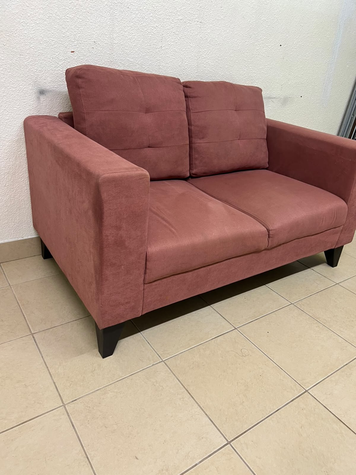 A red or dark pink two-seater fabric sofa featuring wide armrests and back cushions adorned with a checkered pattern. - Image 3