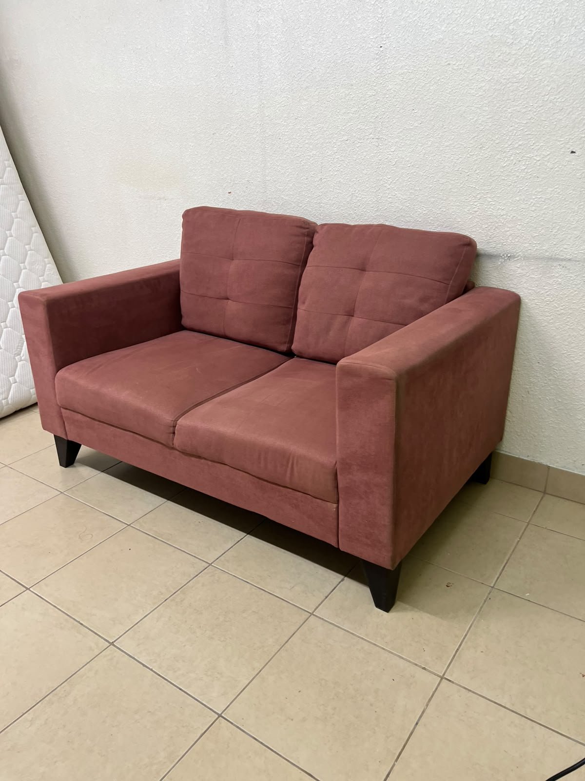 A red or dark pink two-seater fabric sofa featuring wide armrests and back cushions adorned with a checkered pattern. - Image 4