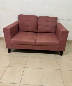 A red or dark pink two-seater fabric sofa featuring wide armrests and back cushions adorned with a checkered pattern.