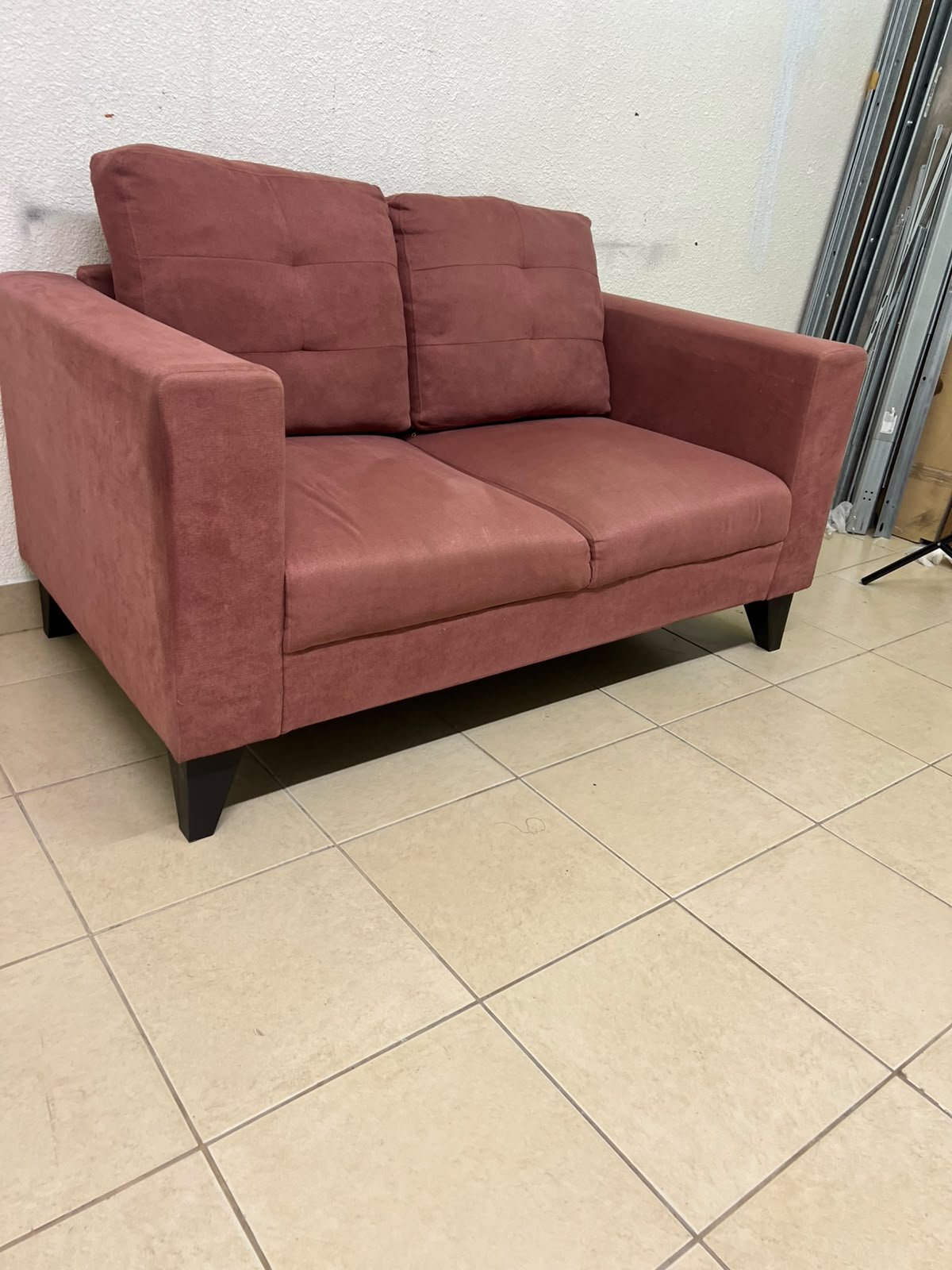 A red or dark pink two-seater fabric sofa featuring wide armrests and back cushions adorned with a checkered pattern. - Image 7