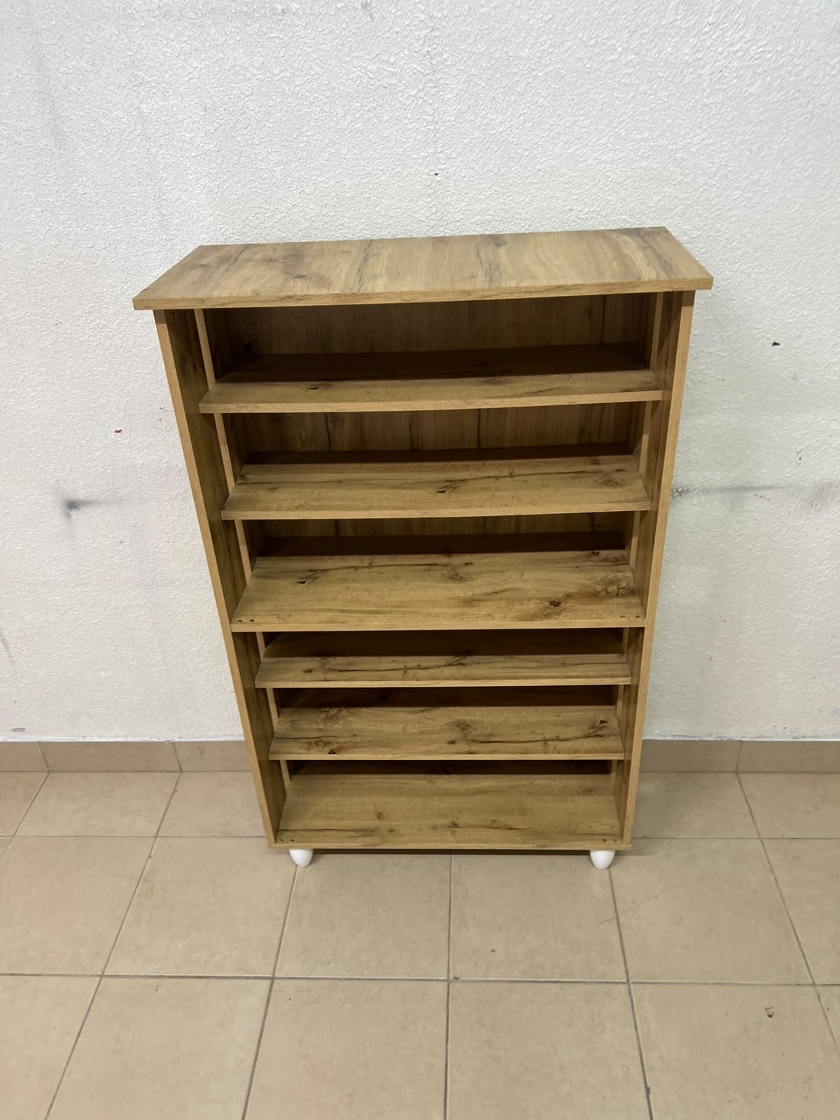 The wooden shoe cabinet, featuring open shelves and small white legs, is a practical and stylish piece for organizing the entryway. - Image 2