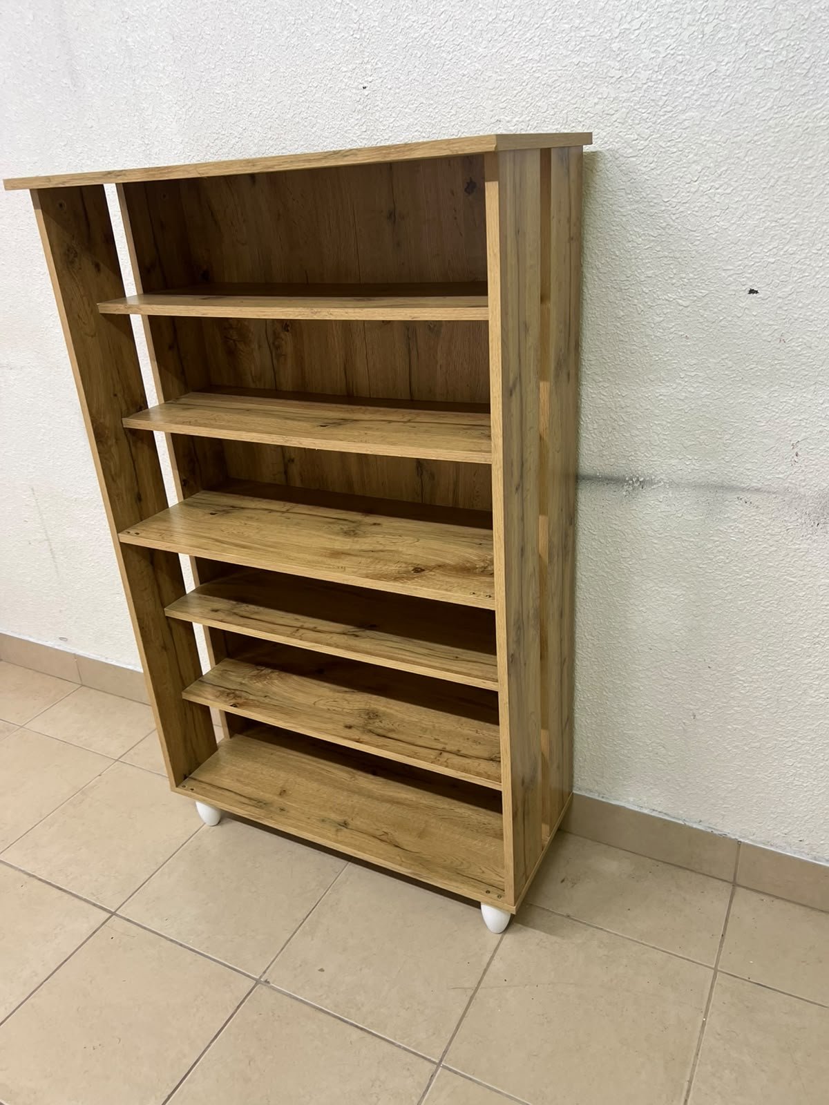 The wooden shoe cabinet, featuring open shelves and small white legs, is a practical and stylish piece for organizing the entryway. - Image 3