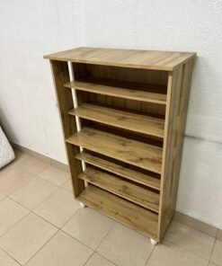 The wooden shoe cabinet, featuring open shelves and small white legs, is a practical and stylish piece for organizing the entryway.