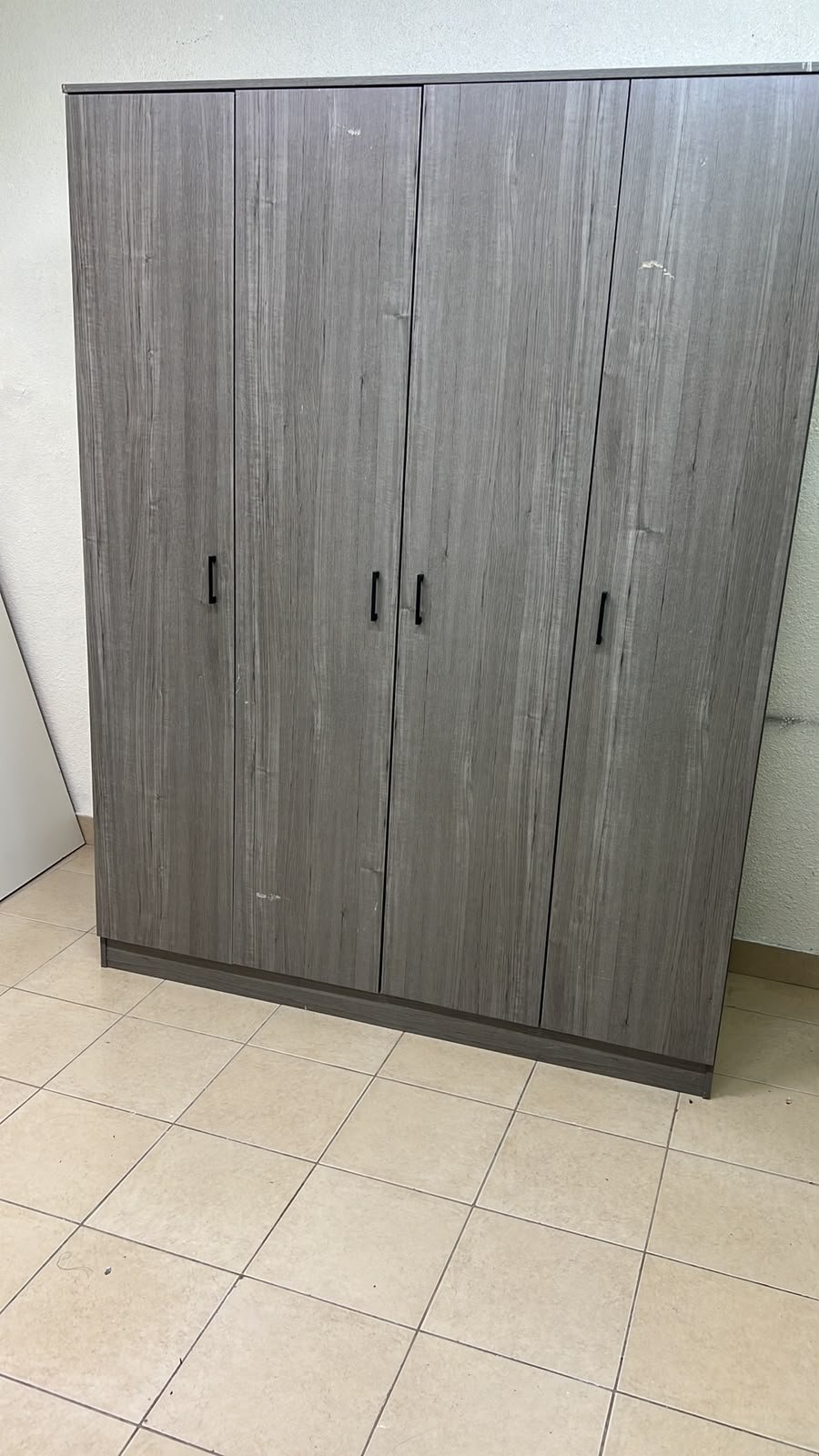 The image shows the Jamora four-door wardrobe from Danube Home, featuring a warm grey color and a practical design with hinged doors and simple black handles. - Image 2
