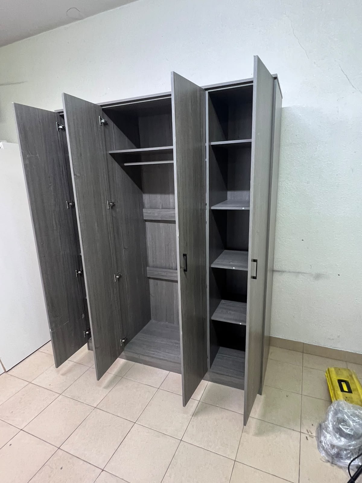 The image shows the Jamora four-door wardrobe from Danube Home, featuring a warm grey color and a practical design with hinged doors and simple black handles. - Image 5