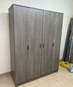 The image shows the Jamora four-door wardrobe from Danube Home, featuring a warm grey color and a practical design with hinged doors and simple black handles.