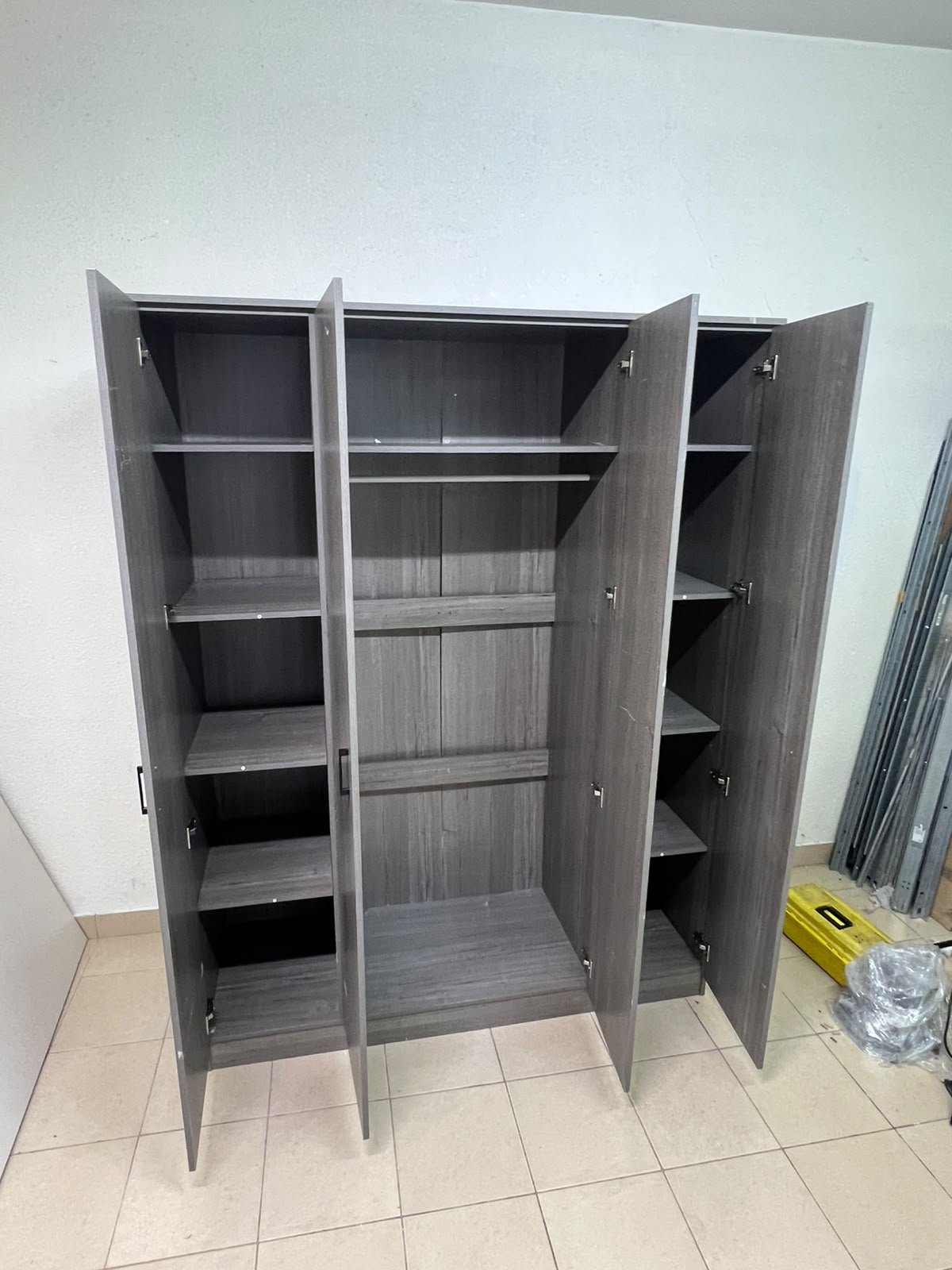 The image shows the Jamora four-door wardrobe from Danube Home, featuring a warm grey color and a practical design with hinged doors and simple black handles. - Image 10