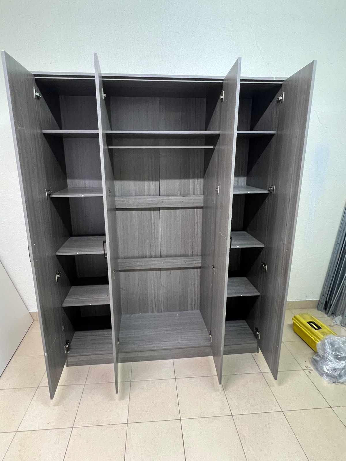 The image shows the Jamora four-door wardrobe from Danube Home, featuring a warm grey color and a practical design with hinged doors and simple black handles. - Image 11