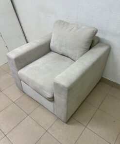 The single chair, upholstered in light gray fabric, resembles modern seating designs characterized by wide, comfortable armrests.