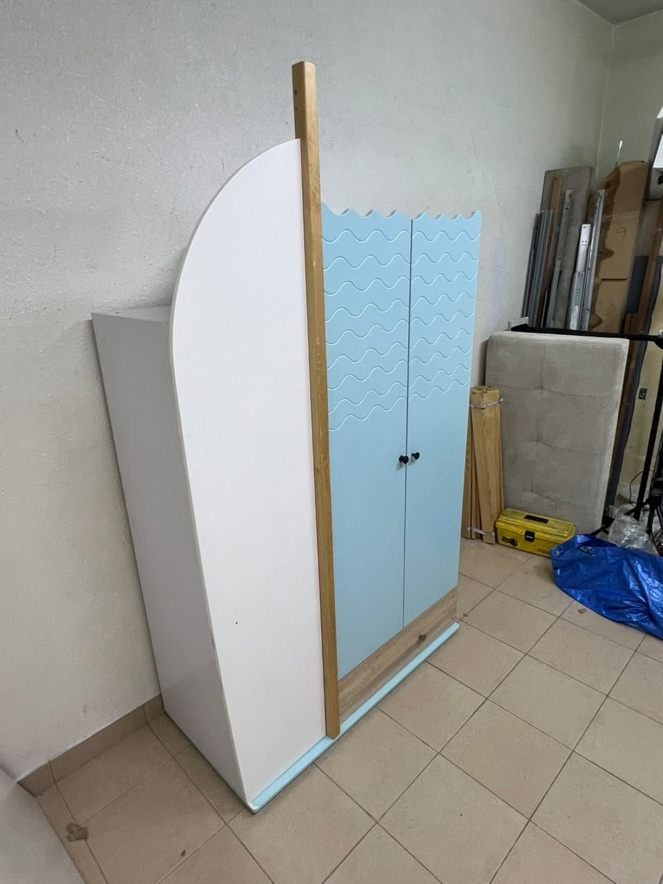 The photo shows a children's wardrobe with a distinctive nautical design in blue and white with wooden details and wave-like top edges. - Image 2