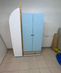 The photo shows a children's wardrobe with a distinctive nautical design in blue and white with wooden details and wave-like top edges.