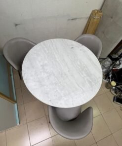 An elegant 110 cm round dining table featuring a white marble top and a black crossed metal base, surrounded by curved grey chairs with an ergonomic design. - Image 8