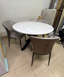 An elegant 110 cm round dining table featuring a white marble top and a black crossed metal base, surrounded by curved grey chairs with an ergonomic design. - Image 7