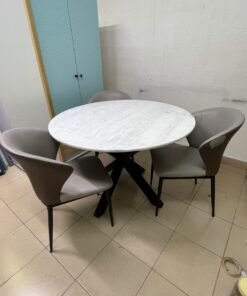 An elegant 110 cm round dining table featuring a white marble top and a black crossed metal base, surrounded by curved grey chairs with an ergonomic design. - Image 6
