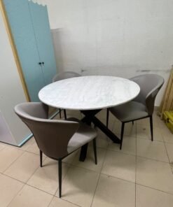 An elegant 110 cm round dining table featuring a white marble top and a black crossed metal base, surrounded by curved grey chairs with an ergonomic design. - Image 5