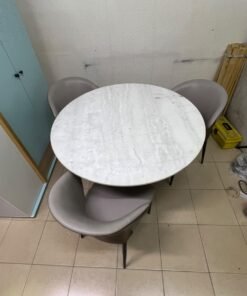 An elegant 110 cm round dining table featuring a white marble top and a black crossed metal base, surrounded by curved grey chairs with an ergonomic design. - Image 4