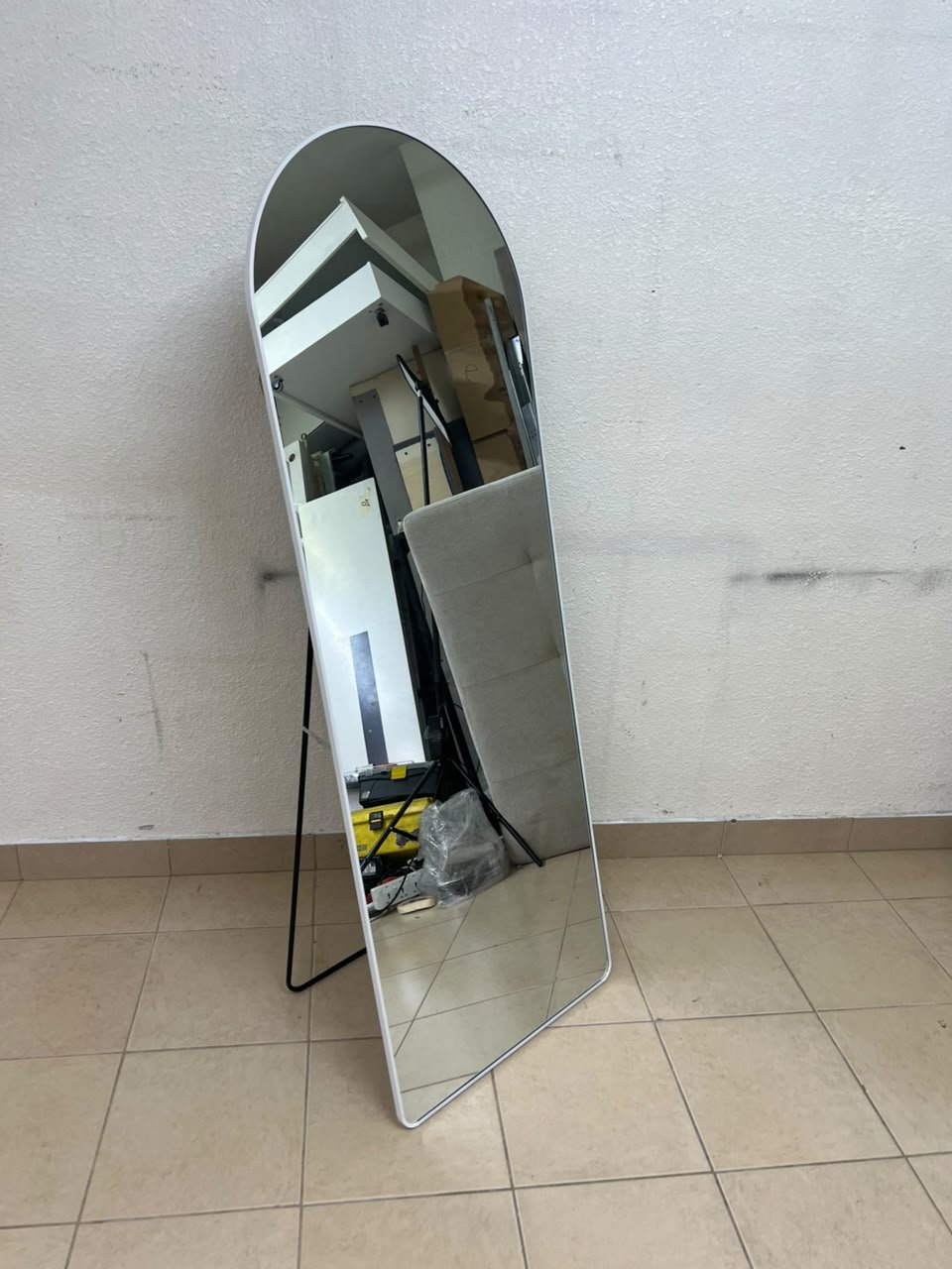 A full-length floor mirror featuring an arched design with a curved top, a white frame, and a black metal back stand; it resembles the Noon East arched mirrors available on Noon or similar freestanding mirror designs found on Amazon UAE.