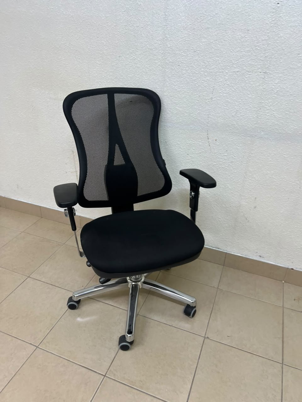 The Topstar Head Point is a comfortable office chair featuring a breathable black mesh back with built-in lumbar support and a shiny silver metal base.