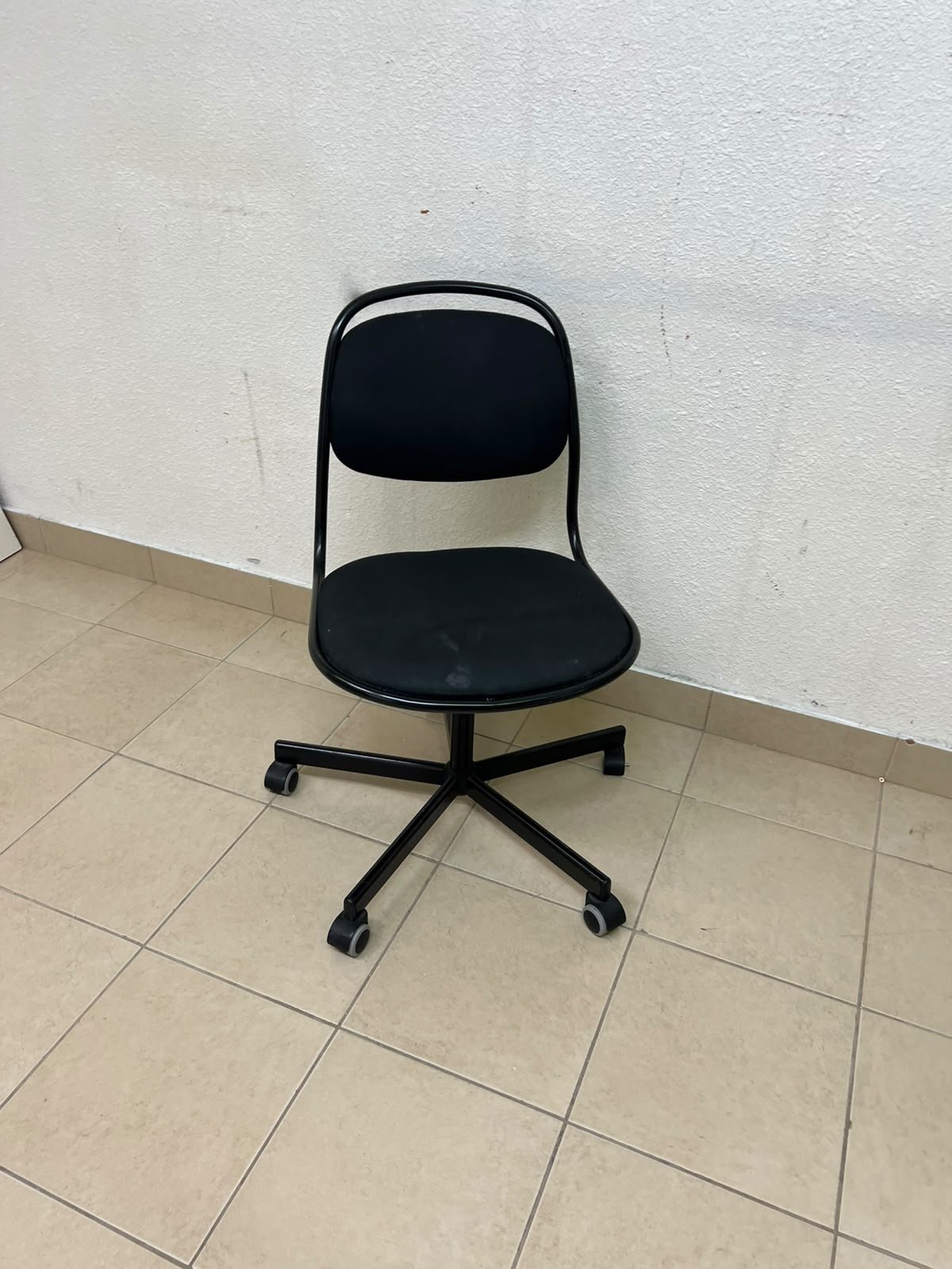 A comfortable office chair featuring a black backrest, built-in lumbar support, and a metal base.
