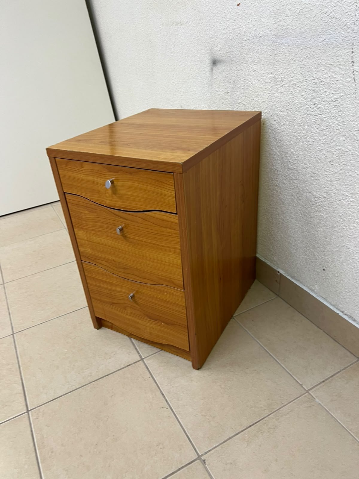 A wooden side table (nightstand) featuring three drawers with slightly curved fronts and small, round handles. - Image 2
