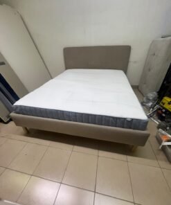 An IKEA bed with a foam and spring mattress—resembling the VALEVÅG or VESTERÖY models—featuring an upholstered bed frame in light gray or beige. - Image 9