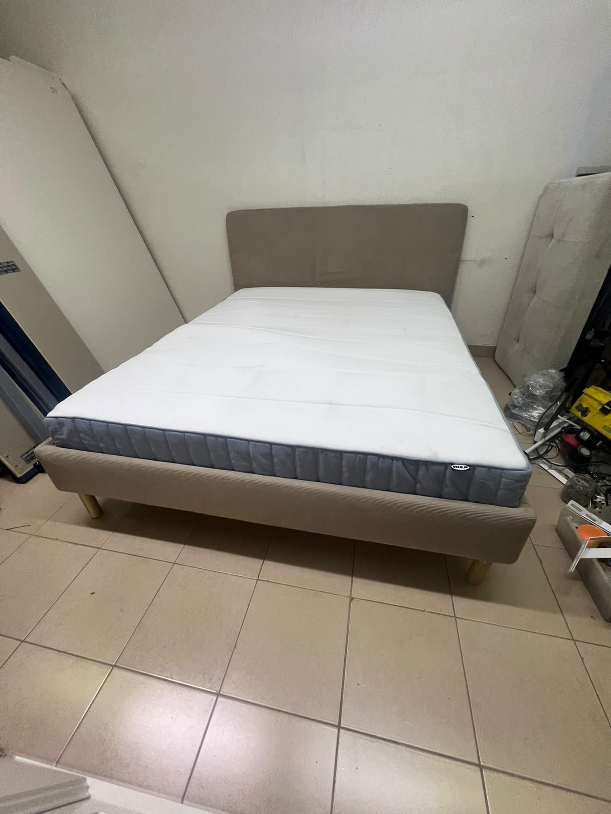 An IKEA bed with a foam and spring mattress—resembling the VALEVÅG or VESTERÖY models—featuring an upholstered bed frame in light gray or beige. - Image 9