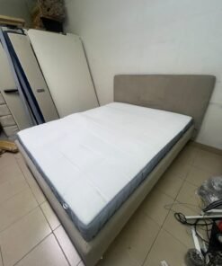 An IKEA bed with a foam and spring mattress—resembling the VALEVÅG or VESTERÖY models—featuring an upholstered bed frame in light gray or beige. - Image 2