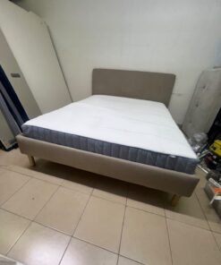 An IKEA bed with a foam and spring mattress—resembling the VALEVÅG or VESTERÖY models—featuring an upholstered bed frame in light gray or beige. - Image 3