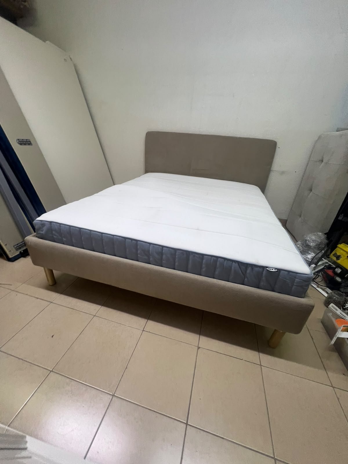An IKEA bed with a foam and spring mattress—resembling the VALEVÅG or VESTERÖY models—featuring an upholstered bed frame in light gray or beige. - Image 3