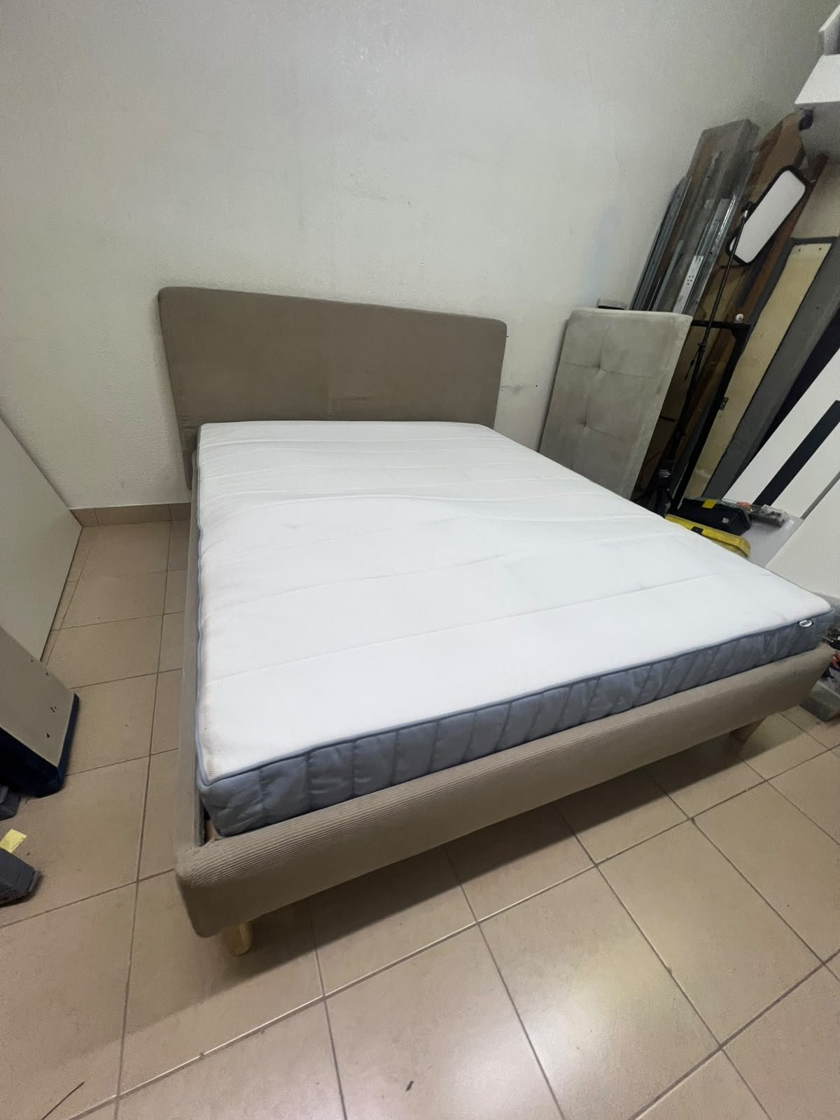 An IKEA bed with a foam and spring mattress—resembling the VALEVÅG or VESTERÖY models—featuring an upholstered bed frame in light gray or beige. - Image 6