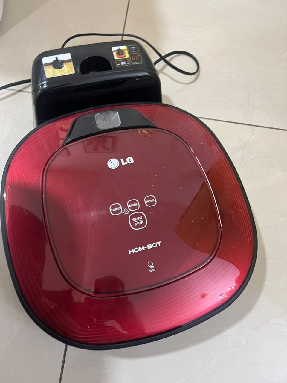 Red square-shaped robotic vacuum cleaner by LG (model LG Hom-Bot VR6270LVMB) with its charging base. - Image 6