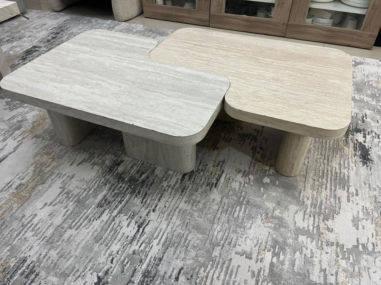 A modern two-piece coffee table set featuring an interlocking geometric design in beige, with a pattern that mimics stone or travertine. - Image 2